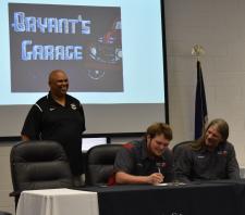 grad signs contract with Bryant's garage