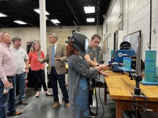 Technical Center Student shows visitor how to use the virtual welder