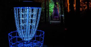 night view of disc golf target lit blue