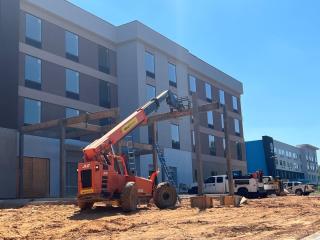 Construction crane lowers final beam onto entryway of new Home2Suites hotel in Campbell County
