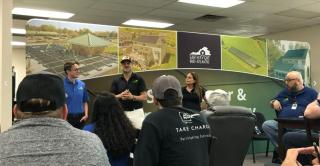 Earth Right Employees give presentation in front of a series of exhibits about solar energy