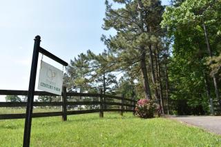 Virginia Century Farm Sign near driveway with trees in background